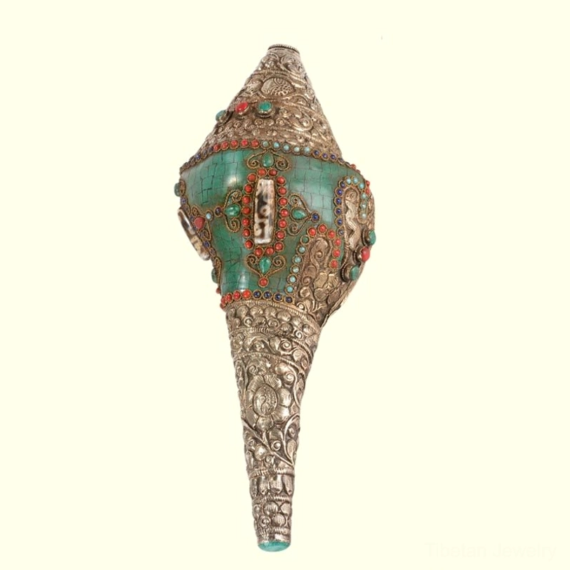 Tibetan shankha conch shell ornament frontal central view on off-white background with symmetrical gem-studded front panel and carved silver tube