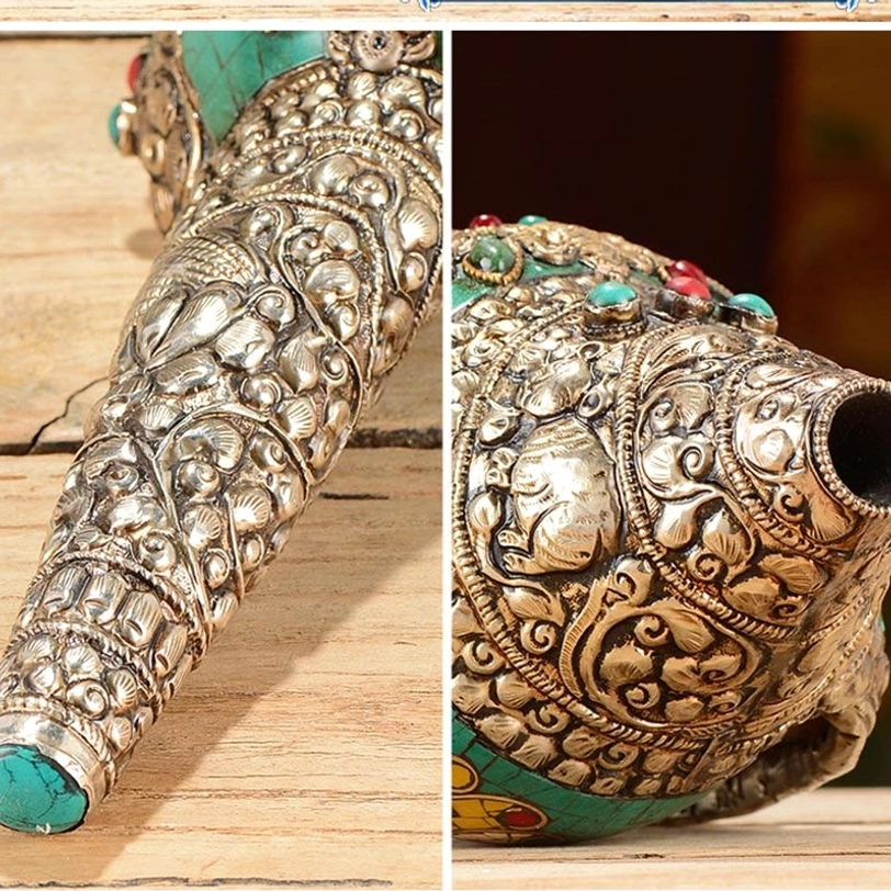 Macro close-up detail of Tibetan shankha conch shell ornament showing silver carved floral and deity patterns with turquoise tip accents