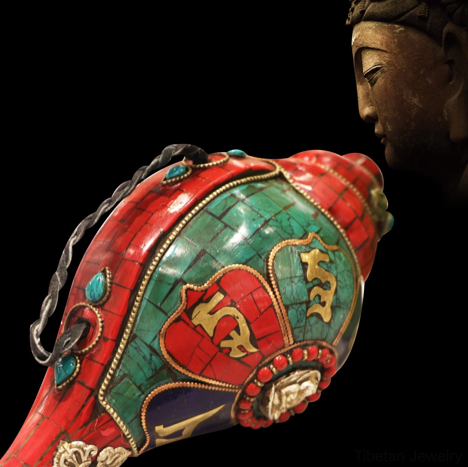 Oblique side angle of sacred Tibetan shankha conch with Sanskrit mantras and black hanging cord