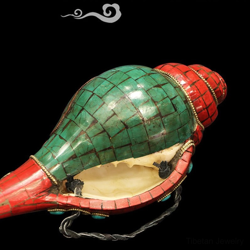 Rear oblique view of sacred Tibetan conch shell showing mosaic design and black hanging cord
