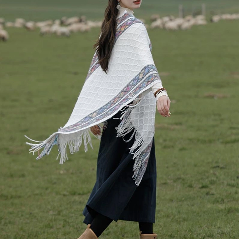 Back view of ethnic rhombus knit poncho shawl with colorful trim and tassel hem