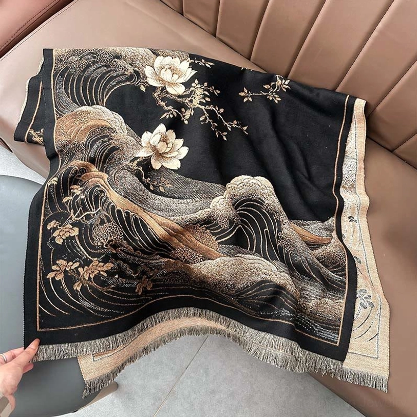 Close-up of black Tibetan shawl hem with hand holding fringe detail on leather sofa