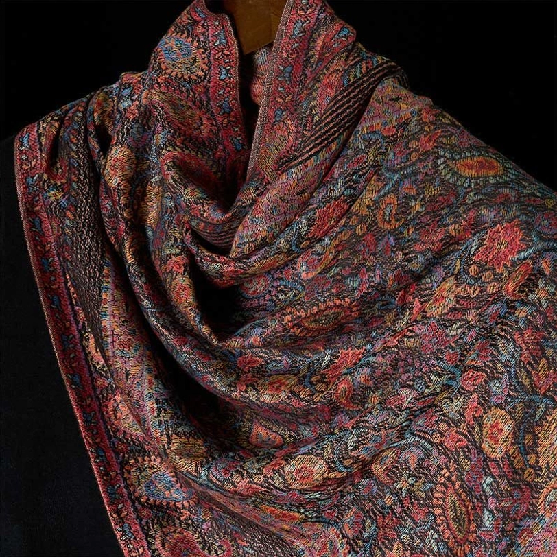 Close-up front view of Tibetan paisley shawl draped fabric, multi-color traditional motifs, and soft woven texture