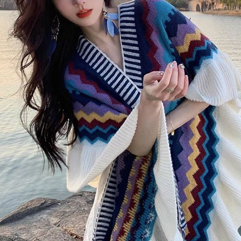 Close-up front view of model in Tibetan zigzag striped shawl wrap at outdoor lakeside location with ruffled cuffs