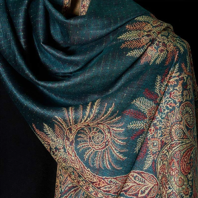 Close-up draped view of Tibetan paisley shawl revealing intricate teal-based woven floral motifs and soft fabric texture