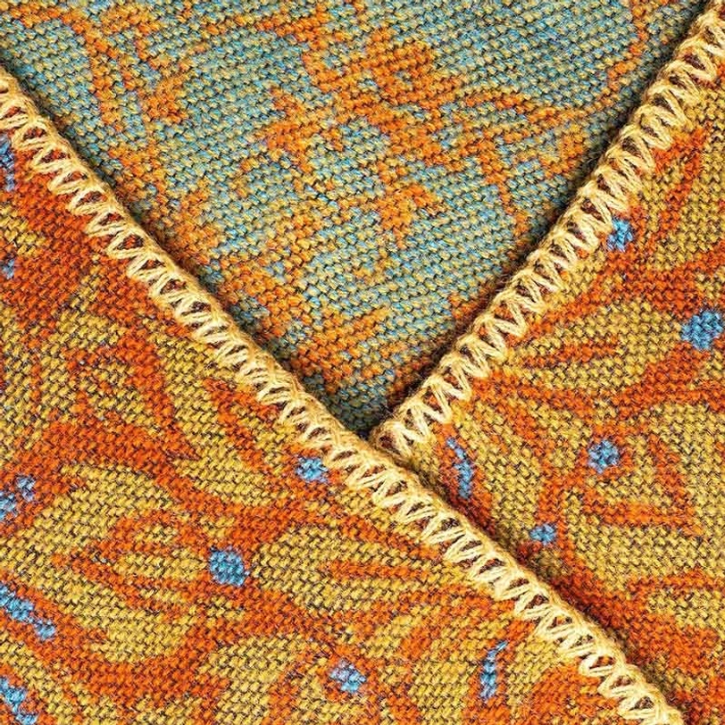 Tibetan shawl multicolor paisley weave texture close-up detail with yellow blanket stitch edges