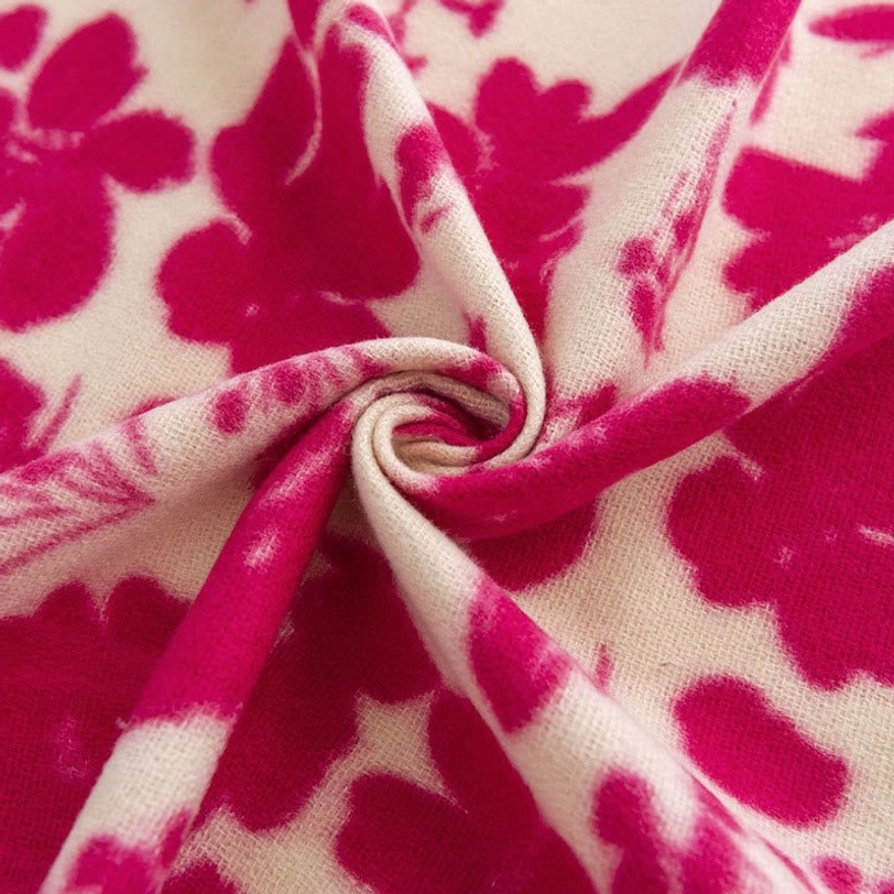 Close-up detail of tibetan shawl fabric showing twisted rose red flower print on soft woven texture