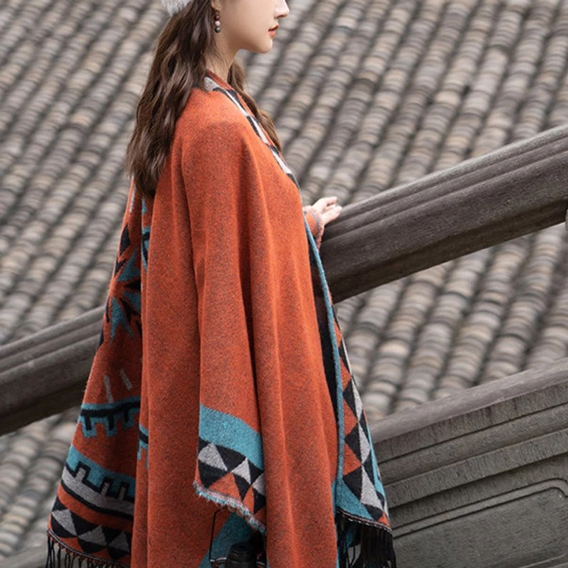 Fabric texture detail of orange geometric tassel shawl showing soft acrylic-polyester blend and intricate tribal design work