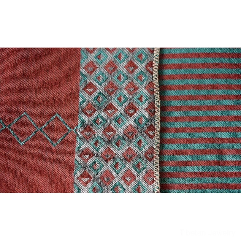 Flat lay of Tibetan diamond striped shawl showing solid, geometric diamond and stripe zones in teal, rust and gray-blue woven jacquard