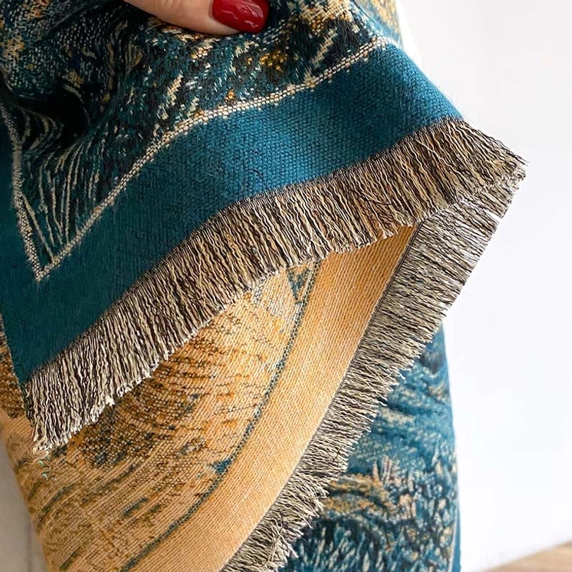 Detail shot of Tibetan shawl hem showing double woven border and thick hand-frayed tassel fringe in teal and cream colors