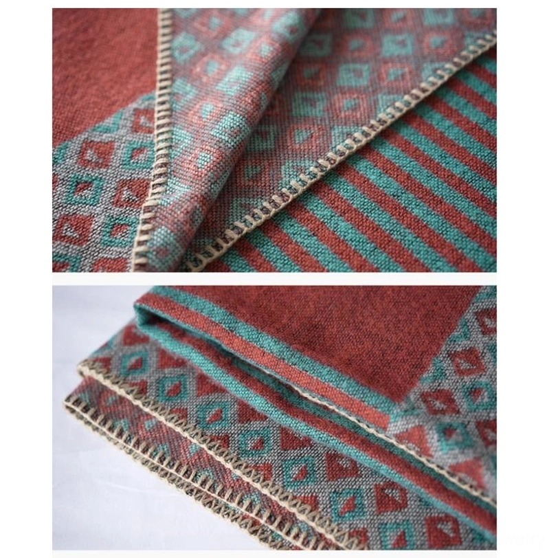 Tibetan shawl hem close-up showing blanket stitch edge trim with geometric pattern and stripe sections in teal and rust color tones