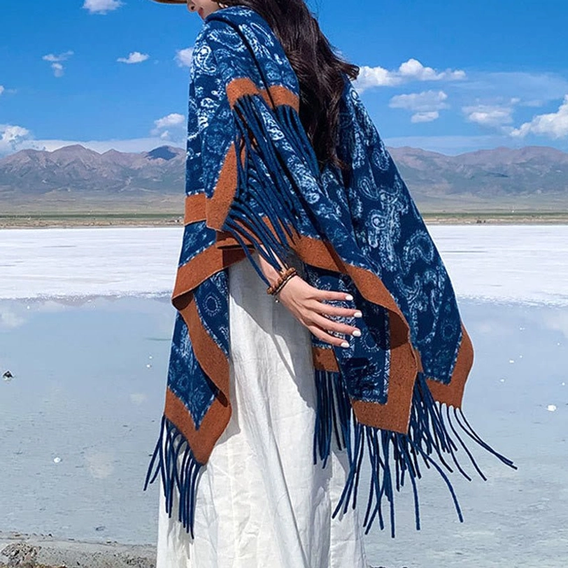 Handwoven Tibetan paisley shawl navy base with white prints and hanging tassels, three-quarter side view at alpine lake with mountain scenery