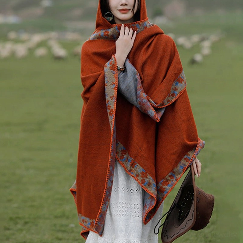 Reversible Tibetan prayer poncho close-up showing burnt orange exterior, floral trim details, and grey inner lining