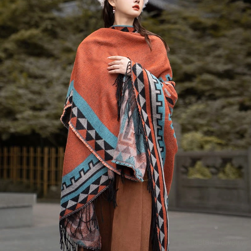 Tassel fringe detail of Tibetan ethnic wrap showing hand-tied decorative hem and geometric lower border patterns