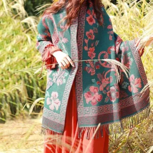 Ethnic tassel shawl with red and pink floral motifs on teal base draped from front