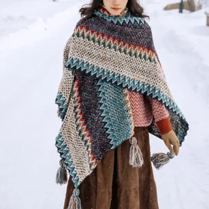 Tibetan wavy knit tassel shawl in blue beige red worn full-body in snowy landscape showing ethnic poncho design