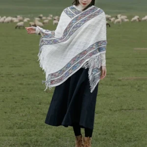 White ethnic tassel poncho shawl full front view with retro tribal trim and fringe hem paired with black long dress