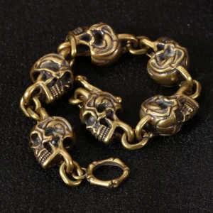 Handcrafted copper skull link bracelet overhead flat lay showing multiple carved skull charms