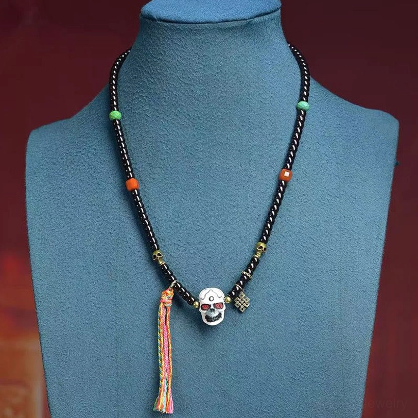 Tibetan coconut shell skull bracelet worn on blue jewelry display mannequin showing fit and design