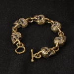 Antique copper brass skull bracelet with toggle clasp, front view on black background