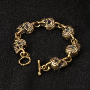 Antique copper brass skull bracelet with toggle clasp, front view on black background