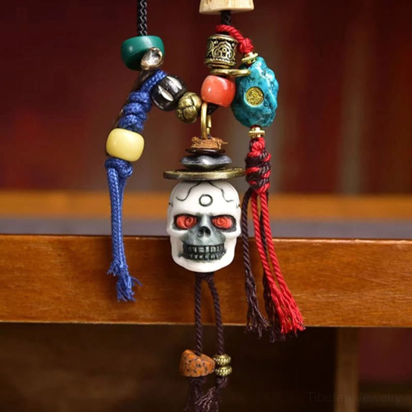 Tibetan skull Lord of Corpse Forest necklace displayed on wooden shelf - frontal view showing skull with turquoise agate beads and tassel