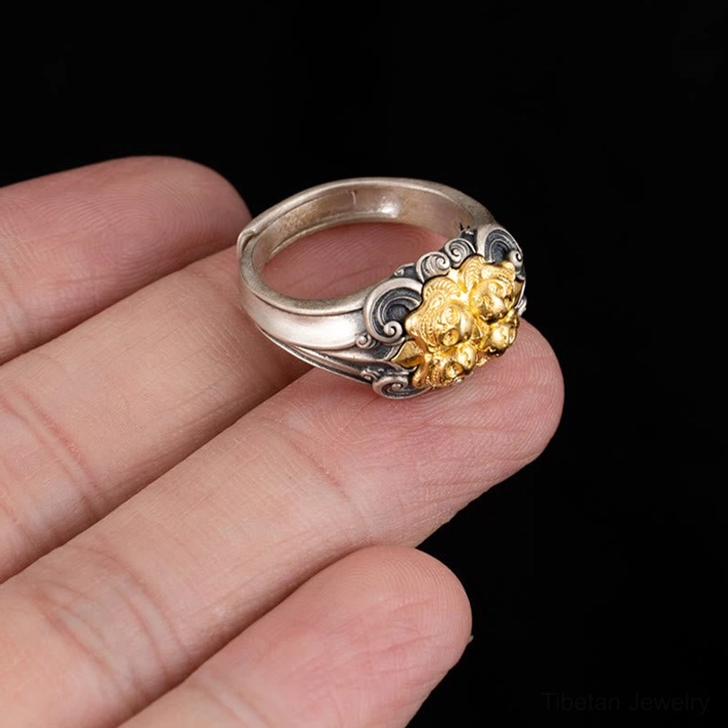 Adjustable sterling silver Tibetan skull ring worn on fingertip showing compact size and engraved design details in natural light