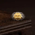 925 sterling silver Tibetan skull protection ring with gold-plated skull motif on dark wooden display stand, adjustable design shown from frontal view