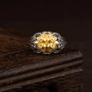 925 sterling silver Tibetan skull protection ring with gold-plated skull motif on dark wooden display stand, adjustable design shown from frontal view