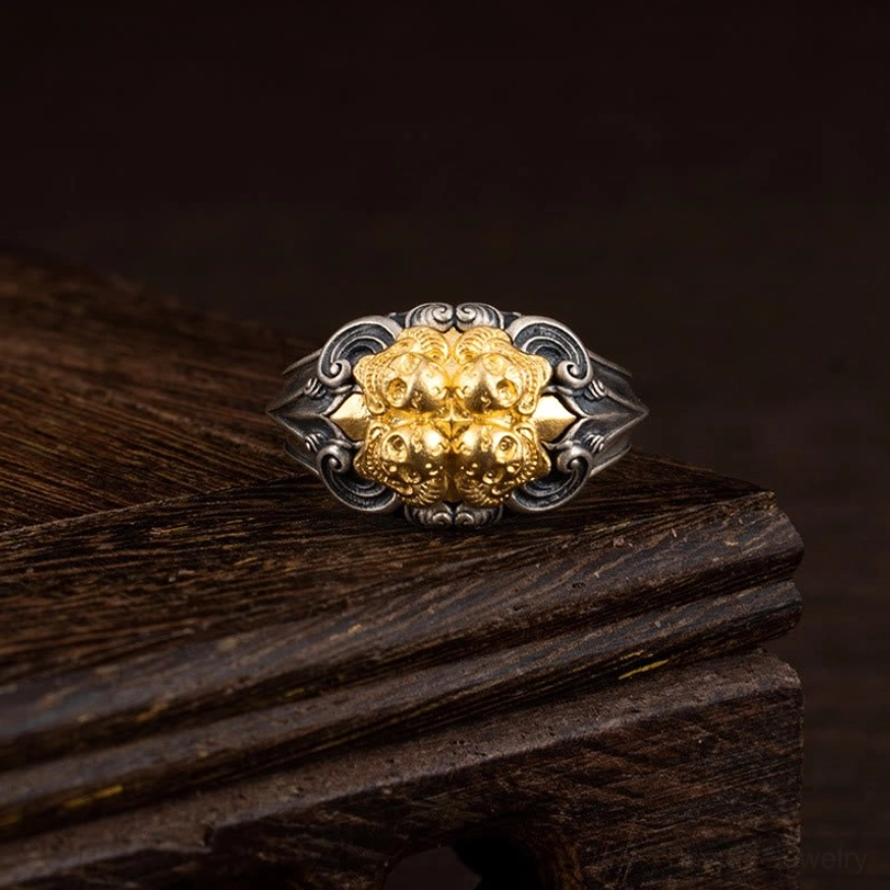 925 sterling silver Tibetan skull protection ring with gold-plated skull motif on dark wooden display stand, adjustable design shown from frontal view