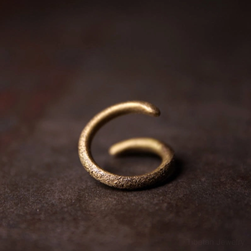Open spiral metal ring front view macro photography showcasing rough bronze grain texture