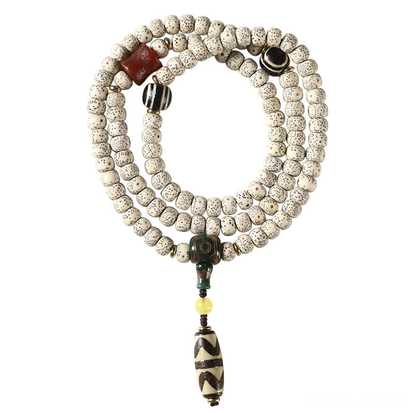 Circular displayed Tibetan bodhi mala bracelet with off-white star moon seeds, black round spacers, and multi-part protective Dzi