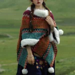 Tibetan multicolor striped poncho shawl with faux fur trim worn on model outdoors showing geometric ethnic pattern and white collar detail