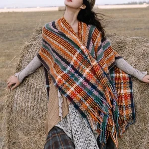 Tibetan striped tassel shawl with colorful geometric patterns displayed on grassland, front three-quarter view showing vibrant bohemian design