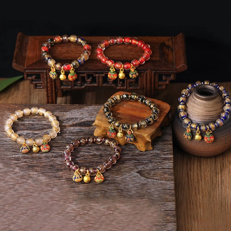 Tibetan gold swallowing beast blessing bracelet featuring sacred liuli glass and protective charms
