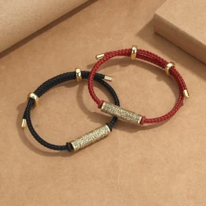 Tibetan red and black handwoven protection bracelets with gold and silver metal tubes, displayed on kraft paper in flat lay style
