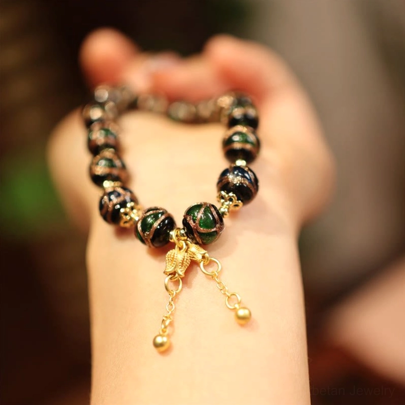 Tibetan tassel charm bracelet with mixed dark beads, gold tassel ornament and adjustable metal accents on wrist