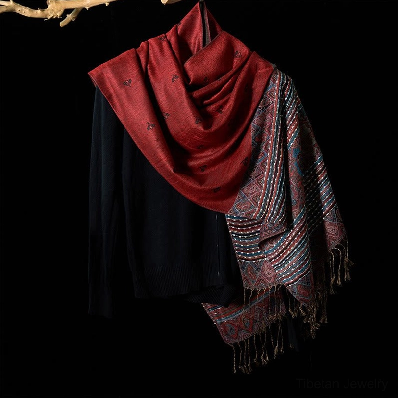 Tibetan handwoven shawl with tassels displayed front view, showing the full drape and intricate geometric patterns transitioning from solid red to woven patterned fabric