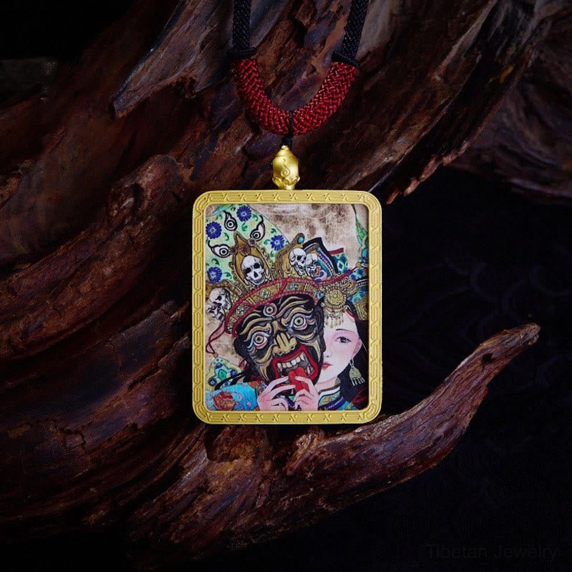 Hand-painted Tibetan thangka deity pendant with gold frame and colorful mythic artwork on dark wood surface with red woven cord