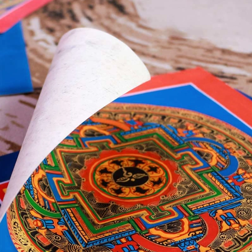 Close-up detail of Tibetan thangka gilt painting showing intricate Sanskrit mantra work and color layering