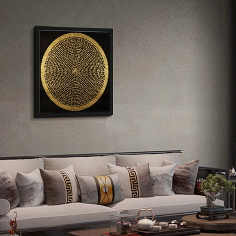 Tibetan thangka with pure gold circular mandala mounted on white wall in modern living room setting