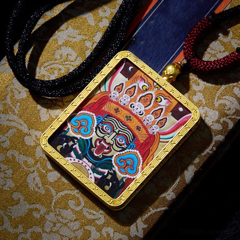 Tibetan thangka hand-painted pendant showcasing detailed celestial deity artwork with gold frame and protective glass covering