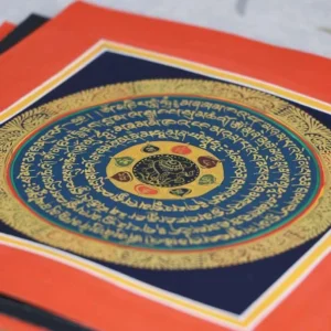 Tibetan handmade thangka painting with sacred mandala design and red border mat, top-down flat view