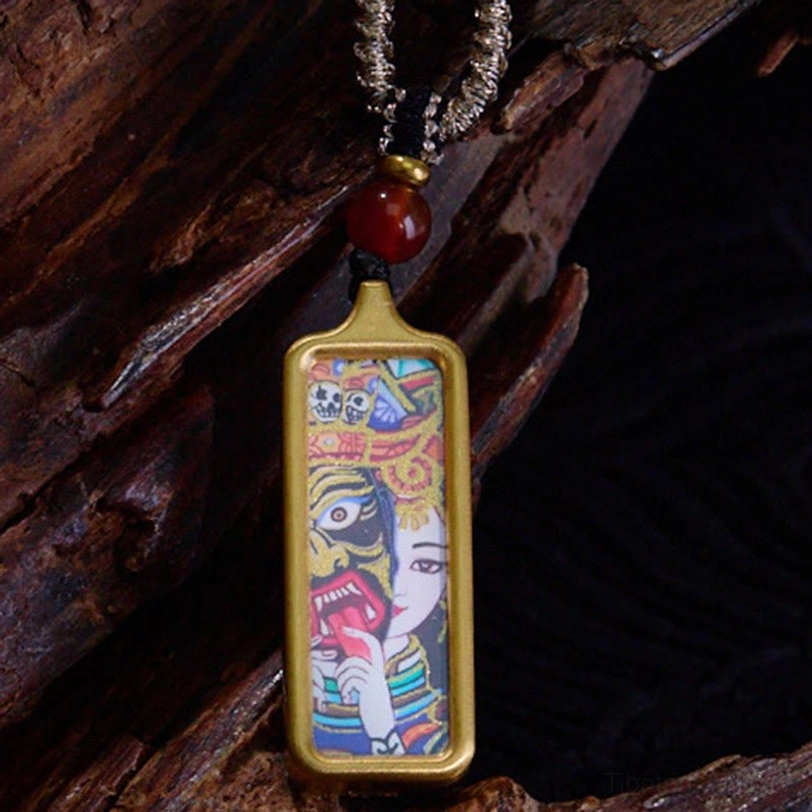 Tibetan thangka necklace with hand-painted deity artwork in gold frame, red agate bead, and braided silver chain, side view close-up