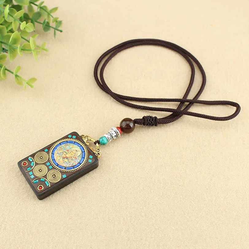 Tibetan wealth thangka pendant necklace top-down flat lay showing complete pendant design and cord structure