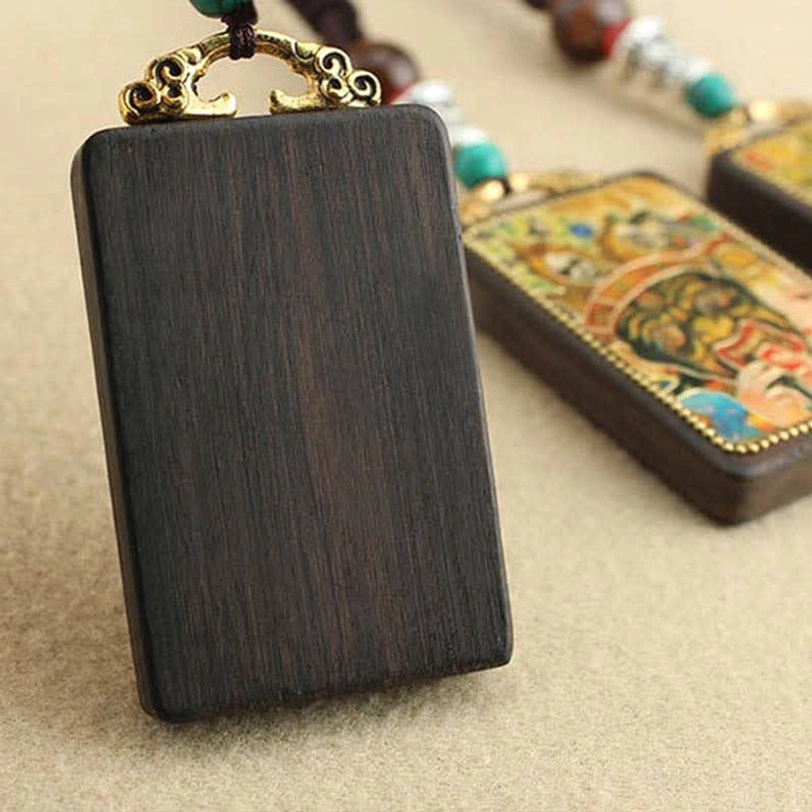 Tibetan thangka pendant necklace with intricate deity artwork and authentic handmade ebony wood craftsmanship