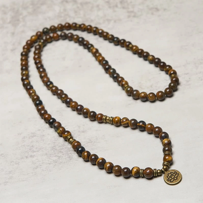 Long tiger eye bead necklace with lotus charm pendant, angled view showing uniform round beads