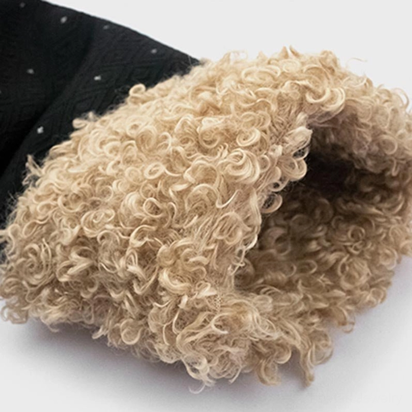 Cuff detail of Tibetan fleece-lined top showing soft curly beige fleece against black dotted outer fabric