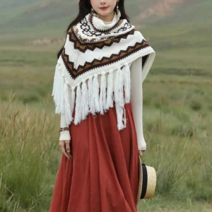 Tibetan triangular shawl with white base and brown zigzag ethnic stripe pattern, displayed on grassland with long tassel hem