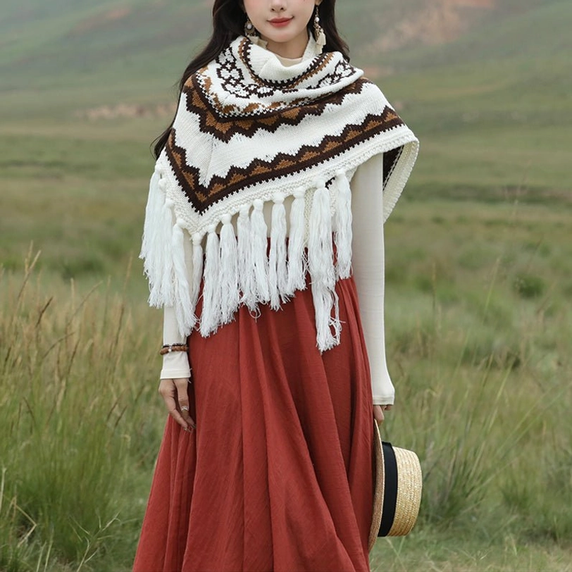 Tibetan triangular shawl with white base and brown zigzag ethnic stripe pattern, displayed on grassland with long tassel hem